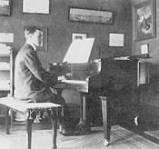 Gerhard at his new Chickering baby grand piano, St. Paul, February 1918. His sister Theresia's painting of Jesus hangs above the piano.